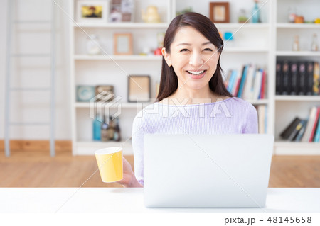 部屋でラップトップコンピューターを見る女性 部屋でラップトップコンピューターを見る女性 48145658