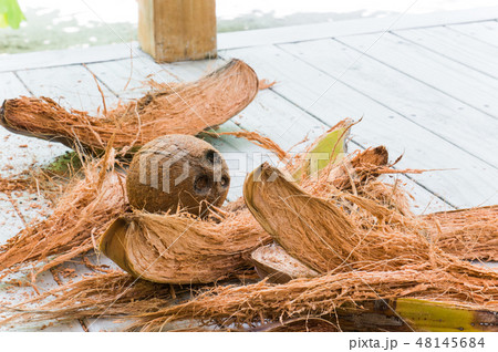 Husked coconut with fiber on white wooden floor Husked coconut with fiber on white wooden floor 48145684