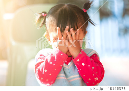 asian girl closing her face and playing peekaboo 48146373