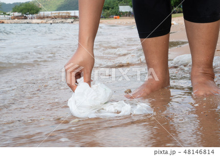 Woman collecting garbage on the beach Woman collecting garbage on the beach 48146814