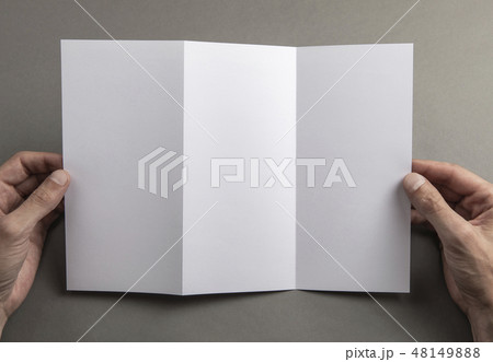 Mens hands holding white booklet Mens hands holding white booklet 48149888