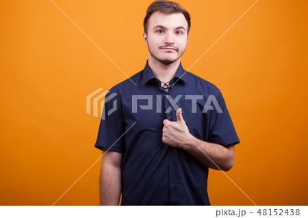 Handsome young man showing thumb up on yellow background 48152438
