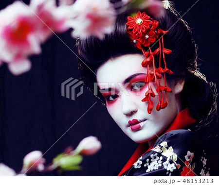 young pretty real geisha in kimono with sakura and decoration on black background young pretty real geisha in kimono with sakura and decoration on black background 48153213