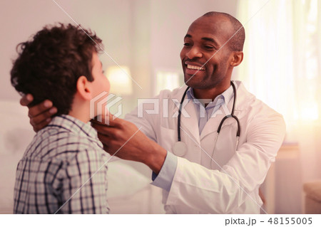 Careful doctor providing the examination of child throat Careful doctor providing the examination of child throat 48155005