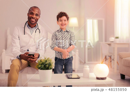 Kid and a doctor sitting in the room 48155050
