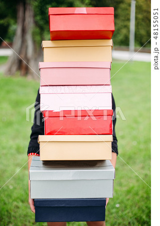 Unrecognizable girl with stack of shoe boxes over 48155051