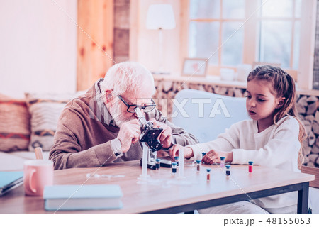 Grey-haired man watching in modern small microscope 48155053