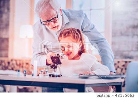 Schooler blinking while using microscope sitting at desk Schooler blinking while using microscope sitting at desk 48155062