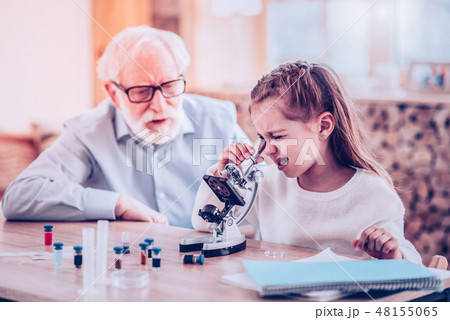 Girl watching in microscope during private lesson 48155065