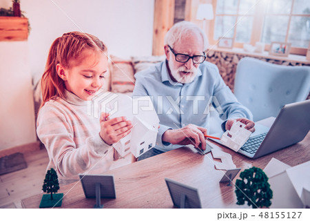 Girl playing constructor with her grandfather at home 48155127