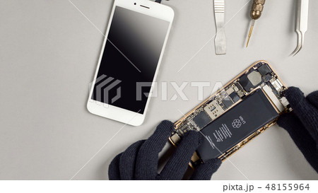 Technician repairing broken smartphone on desk 48155964