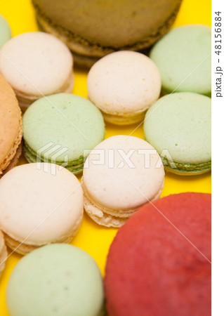 Big cherry macaroon flavour next to different macaroon flavours over yellow background Big cherry macaroon flavour next to different macaroon flavours over yellow background 48156884