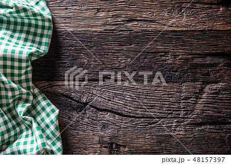 Green checkered kitchen tablecloth on wooden table 48157397