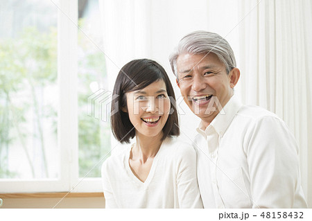 リビングでくつろぐミドル夫婦 48158432