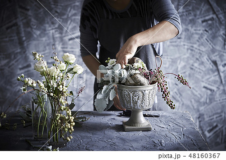 フラワーアレンジメントとする女性 48160367
