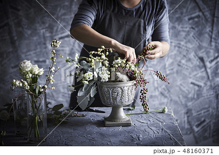 フラワーアレンジメントとする女性 48160371