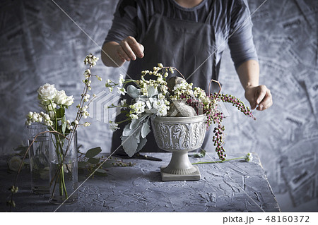 フラワーアレンジメントとする女性 48160372