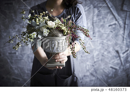フラワーアレンジメントとする女性 48160373