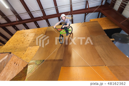 Man riding on a BMX bicycle at an extreme sports park 48162362