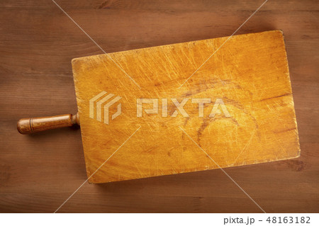 A photo of an old cutting board, shot from the top on a dark rustic texture with a place for text. A A photo of an old cutting board, shot from the top on a dark rustic texture with a place for text. A 48163182