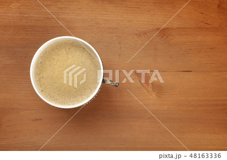An overhead photo of coffee in a vintage cup, shot from the top on a dark rustic wooden background An overhead photo of coffee in a vintage cup, shot from the top on a dark rustic wooden background 48163336
