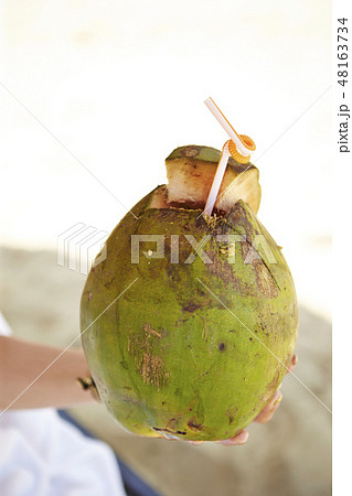 ココナッツジュースを持つ女性の手 ヤシの実 夏イメージ ココナッツジュースを持つ女性の手 ヤシの実 夏イメージ 48163734