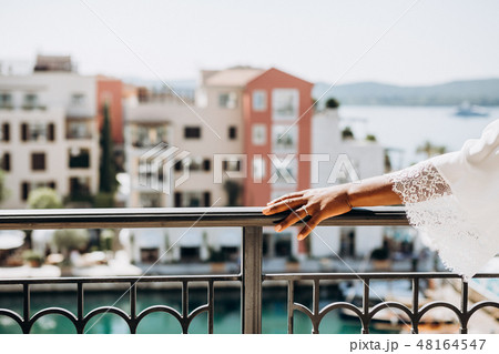black brides hand railing terrace overlooking sea 48164547