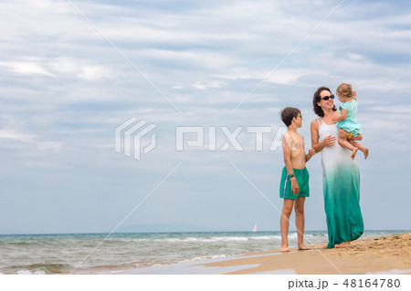 Young mother with her two kids on tropical beach vacation Young mother with her two kids on tropical beach vacation 48164780