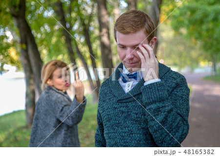 Couple is quarrelling because of the disagreements between them in park. Woman showing middle finger Couple is quarrelling because of the disagreements between them in park. Woman showing middle finger 48165382