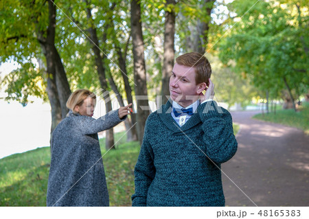 Couple is quarrelling because of the disagreements between them in park. Woman showing middle finger 48165383