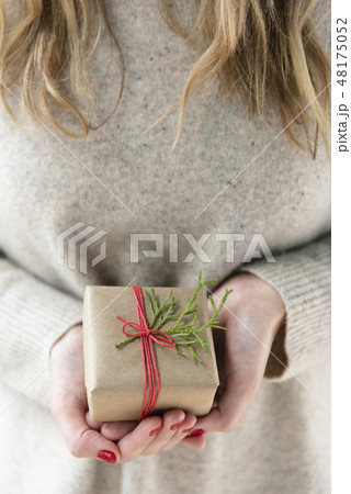 Hands of woman holding Christmas present Hands of woman holding Christmas present 48175052
