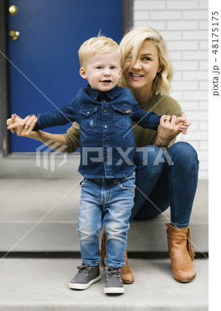 Woman with her son at front door of house 48175175