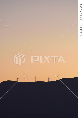 Silhouette of wind turbines on hill at sunset 48175209