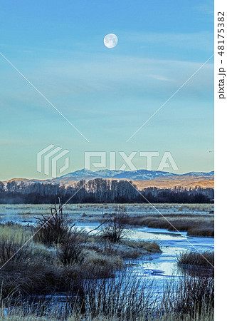 Moon above river in Picabo, Idaho 48175382