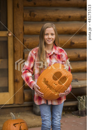 Girl holding Jack O' Lantern Girl holding Jack O' Lantern 48175513