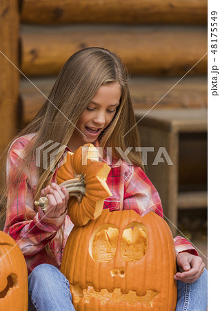 Girl holding Jack O' Lantern Girl holding Jack O' Lantern 48175549