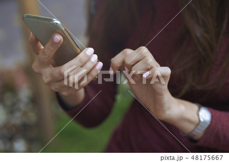 Hands of woman using smart phone 48175667