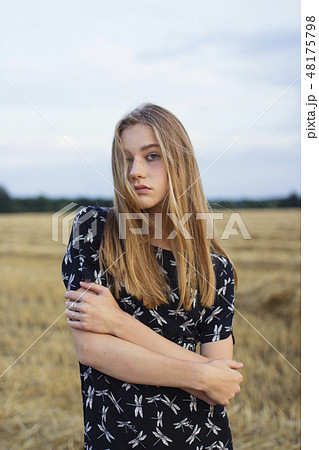 Young woman with arms crossed in field Young woman with arms crossed in field 48175798