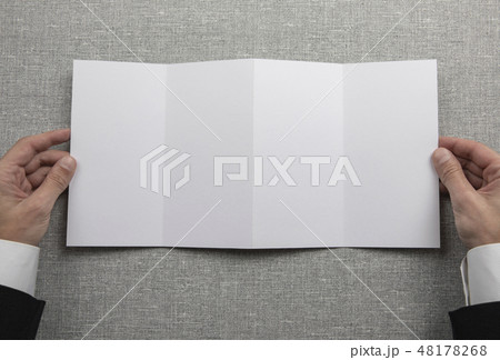 Mens hands holding empty white booklet 48178268