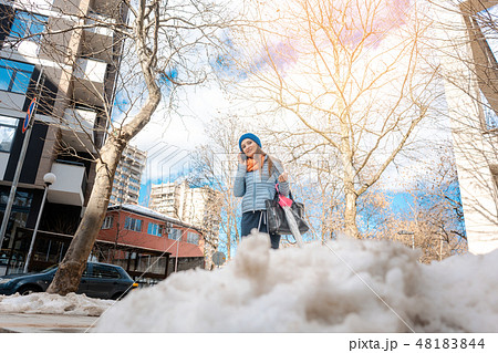 Woman walking through melting snow in late winter 48183844