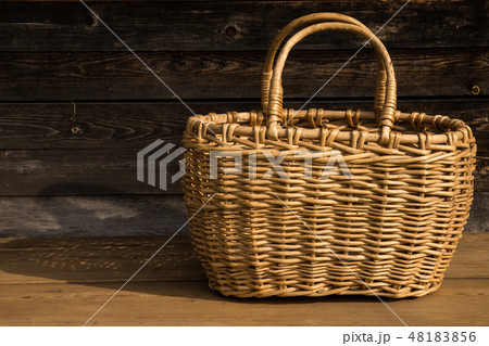 Ancient wicker basket on a wooden background. Selective focus. Free space for text. 48183856