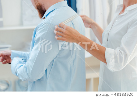 Man in fitting of a bespoke shirt in studio of tailor Man in fitting of a bespoke shirt in studio of tailor 48183920