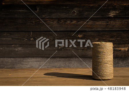 A roll of twine on a wooden background. Selelective focus. Close-up. Free space for text. A roll of twine on a wooden background. Selelective focus. Close-up. Free space for text. 48183948