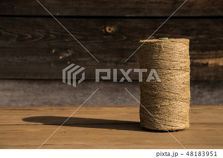 A roll of twine on a wooden background. Selelective focus. Close-up. Free space for text. A roll of twine on a wooden background. Selelective focus. Close-up. Free space for text. 48183951