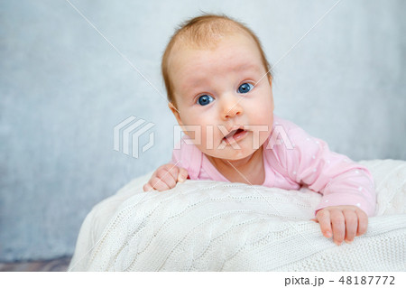 Portrait of a cute newborn baby lying on her stomach Portrait of a cute newborn baby lying on her stomach 48187772
