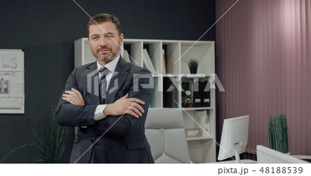 Businessman standing, office interior on background, man in suit. 48188539