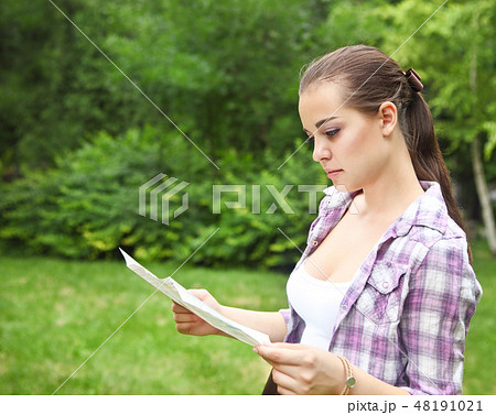 Girl in the countryside holding a map Girl in the countryside holding a map 48191021