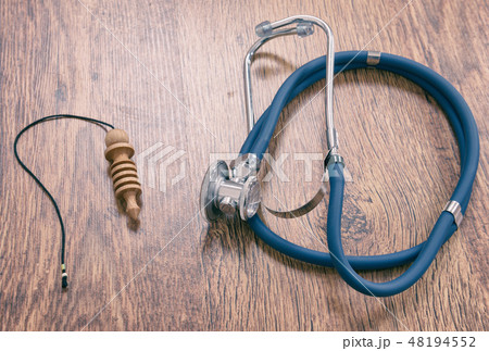 Pendulum and stethoscope on a wooden table Pendulum and stethoscope on a wooden table 48194552