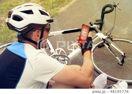 Injured biker holding smartphone calling rescue 48195776