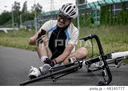 Injured biker holding smartphone calling rescue 48195777